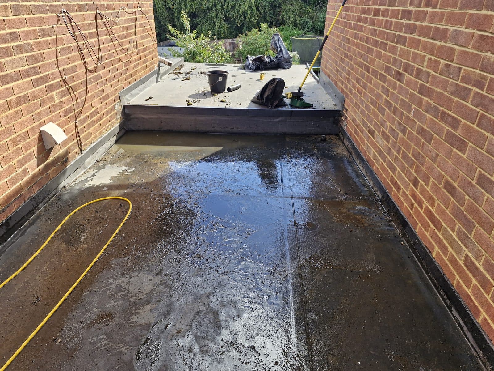 The same flat roof washed clean, the moss gone.